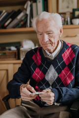 Old man holding medicine blister in hands