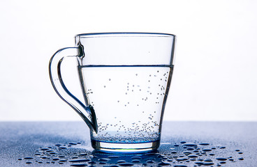 Air bubbles in a glass mug with water on a white background.
