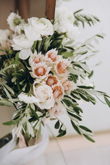Wedding bouquet of flowers and greenery with white ribbon