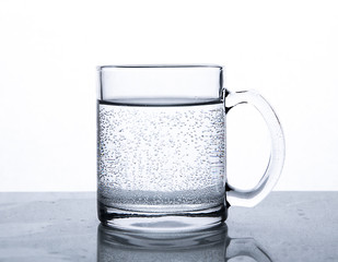 Air bubbles in a glass mug with water on a white background.