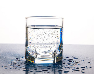 Air bubbles in a glass of water on a white background.