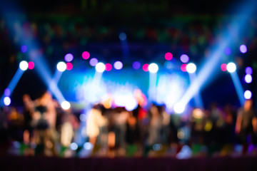 Fototapeta na wymiar The blurred background of the beautiful background of the stage is filled with people who go up to dance. There are a variety of lights illuminating the concept of parties, festivals, pubs and clubs