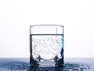 Air bubbles in a glass of water on a white background.