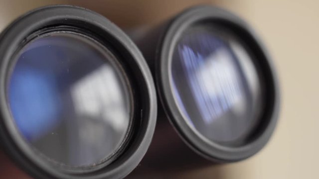 Binoculars Front Lens Reflecting Light and Clouds Close Up