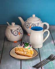 Tea party with homemade cake. Owl-shaped ceramic dishes and vintage forks on a table
