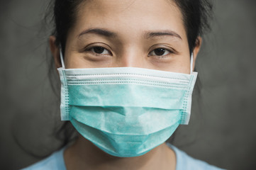 Close up young asian woman wearing protection face mask against coronavirus.
