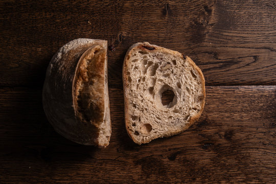 Zdjęcie bochenka chleba i noża na drewnianym, naturalnym stole