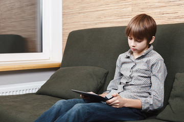 Frustrated boy with tablet confined at home during isolation