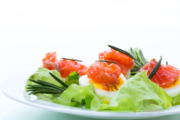 boiled eggs with salted red fish and salad leaves