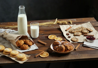 Homemade cakes, cow's milk, dried fruits and spices on a wooden table