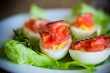 boiled eggs with salted red fish and salad leaves