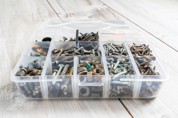 Screws, bolts, nuts and other carpenter stuff in a plastic toolbox (hardware organizer). Stock photo.