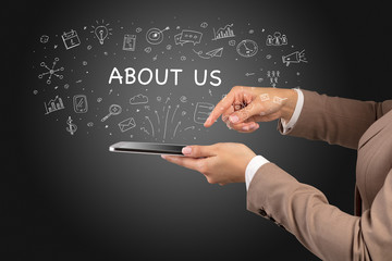 Close-up of a touchscreen with ABOUT US inscription, social media concept