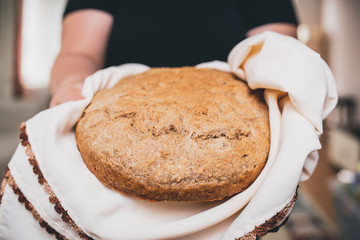 Woman holding tasty fresh homemade bread, close up