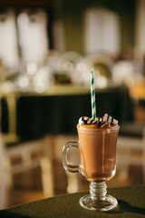 Hot chocolate with marshmellow in a glass with a paper straw. Perfect winter drink.