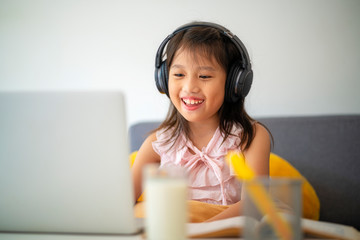 Asian girl using Laptop computer for online study homeschooling during home quarantine....