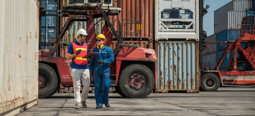 Fototapeta na wymiar Foreman and dock worker staff working checking at Container cargo harbor holding clipboard. Business Logistics import export shipping concept.