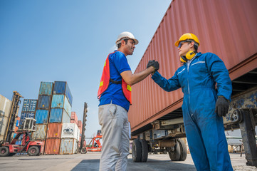 Foreman and dock worker staff shaking hand for sucess working at Container cargo harbor. Business Logistics import export shipping concept.