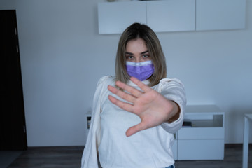 Beautiful girl with protective mask disinfects hands during a virus epidemic.