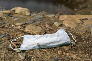 Dirty used medical mask lying on the ground. Coronavirus,COVID-19 concept.