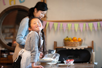 自宅でケーキを作る母と娘