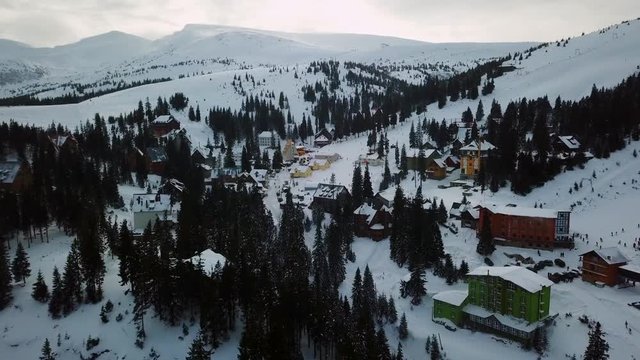 Panoramic view of a ski resort, aerial shot. Aerial shot of a flight over a ski resort in western Ukraine, colorful houses and Christmas trees.