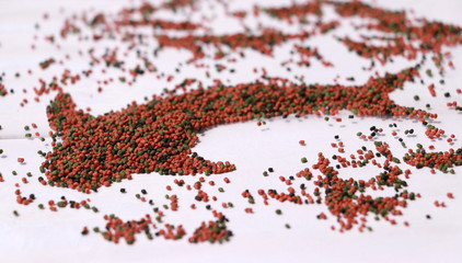 Heap of fish food set to fish shape on the white floor. fish food is food for consumption by fishes.
