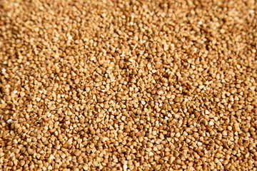 Brown background of buckwheat sprinkled on a table, foreshortening - from above. Concept - stocks...