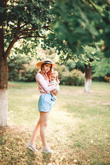 A mother embraces her child in nature against the background of the setting sun