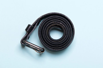 black men's belt on a blue background