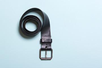 black men's belt on a blue background