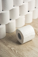 A roll of white toilet paper on background of many rolls, vertical format