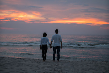 Para podczas zachodu słońca nad morzem