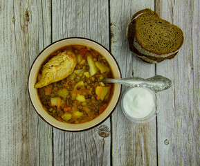 Lentil soup with chicken and sour cream with bread