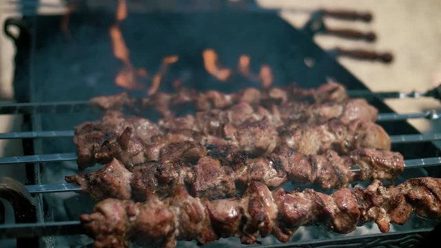 Tasty and juicy skewers on skewers, on an open fire. Slow motion