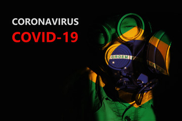 Portrait of a man in a protective mask in the light of the Brazil flag. The inscription Coronavirus Covid-19.