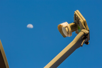 Fototapeta premium Satellite Dish with Moon in the Background Close Up and Clear Blue Sky 
