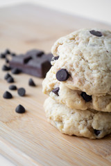 Homemade chocolate chip cookies and dark chocolate in the background