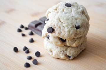 Homemade chocolate chip cookies and dark chocolate in the background