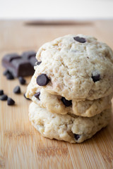 Homemade chocolate chip cookies and dark chocolate in the background