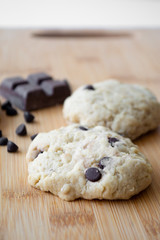 Homemade chocolate chip cookies and dark chocolate in the background