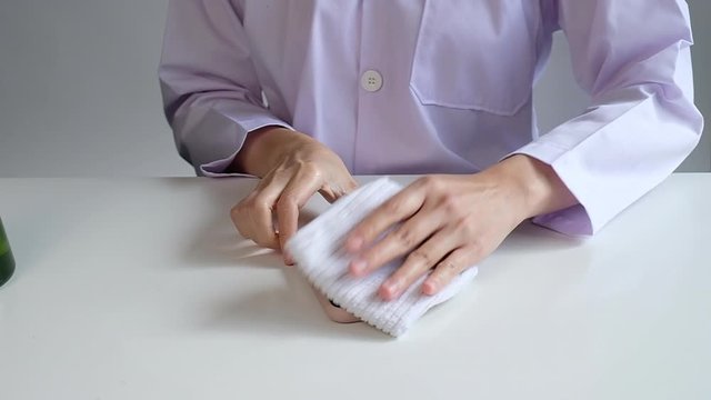 woman cleaning mobile phone surface to sanitize and kill covid19, corona virus and germs. desease prevention.