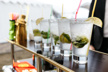 Glasses of ice cold sweating mojito lemonade with lemon slice 