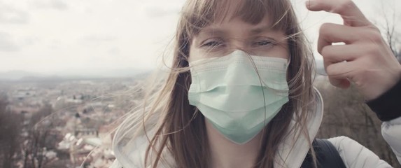 Woman with face mask for protection from virus coronavirus covid 19 pandemic outbreak no travel above isolated city view full of anxiety - Powered by Adobe
