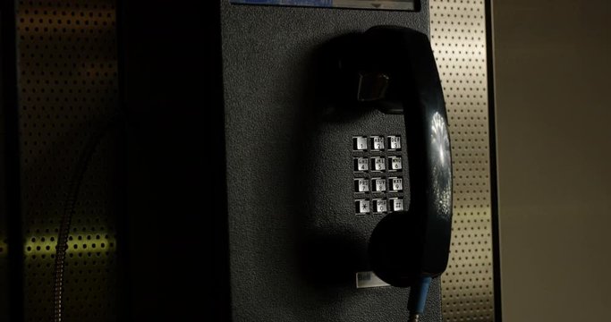 Payphone hanging on wall in isolated corner - close up