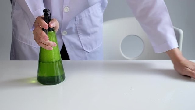 woman cleaning table top surface to sanitize and kill covid19, corona virus and germs. desease prevention.