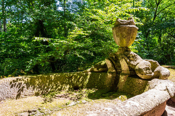 Old sculpture in Sacro Bosco, Parco dei Mostri or Park of the Monsters in Bomarzo, Province of Viterbo, Lazio, Italy, large stone basin with a decorative vase