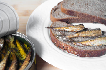 Canned sprats on rye bread served with herb baked potatoes