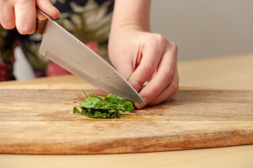 Cooking spinach leaves on a cutting Board in the kitchen.