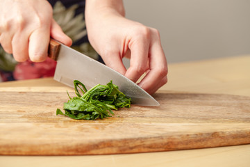 Cooking spinach leaves on a cutting Board in the kitchen.